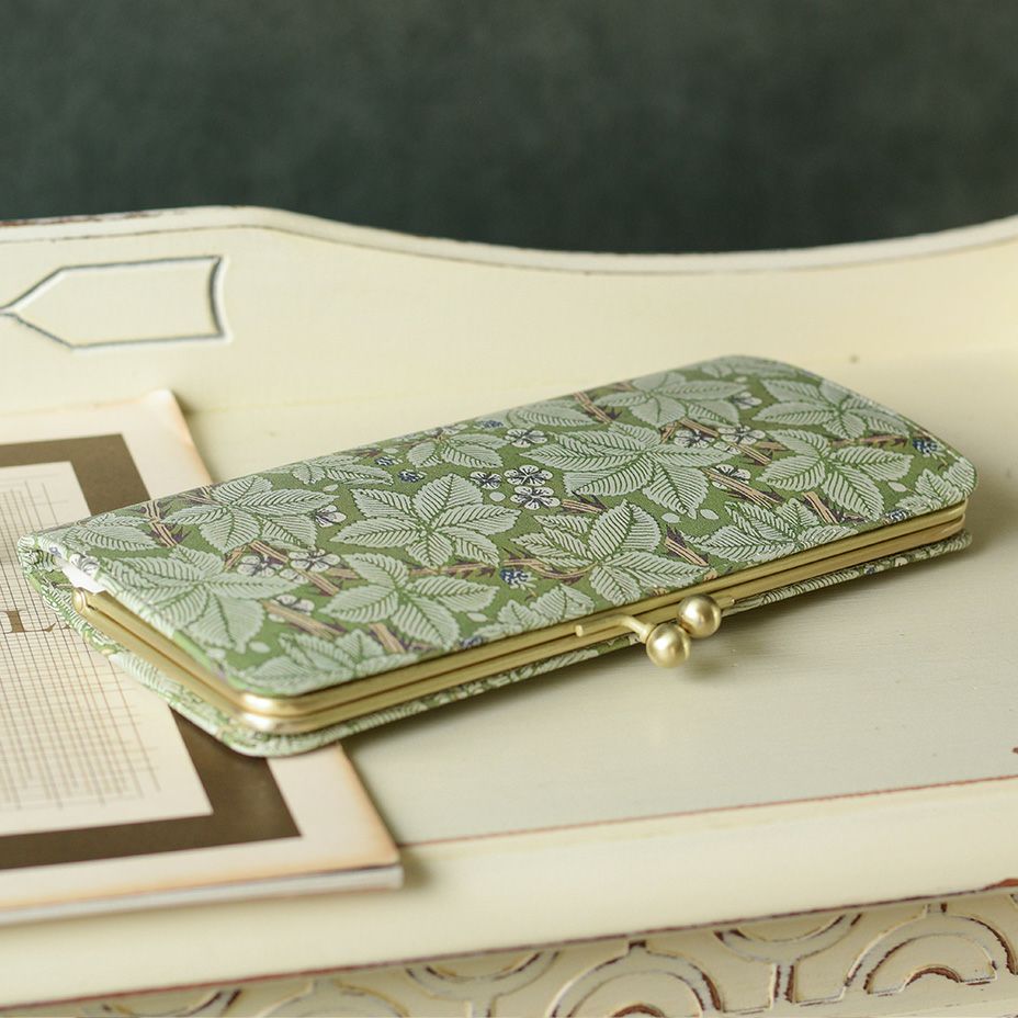 生け垣をうねりながら登っていく蔦や棘には力強い生命力を、葉や白い花の丸みのあるタッチからは愛らしさや優しさを感じられます。